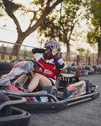 Person in a go-kart with a helmet on a track